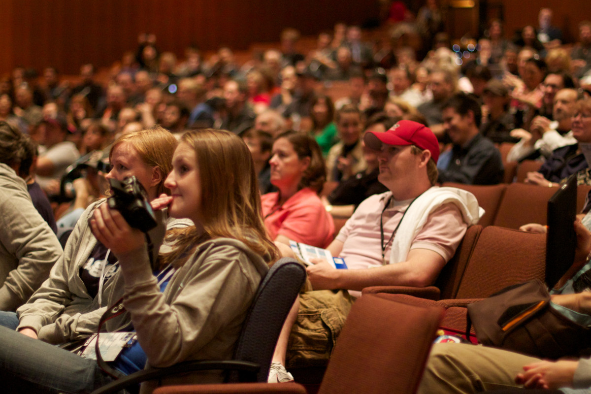 Conference audience speaker presentation applauding after recent community attendance works